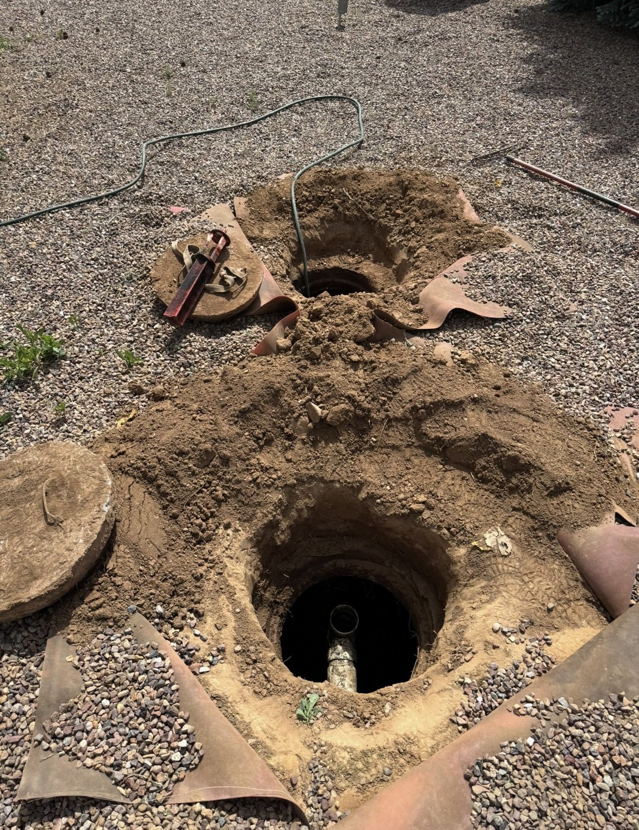Two uncovered septic tank access lids ready for inspection at a White Mountains home
