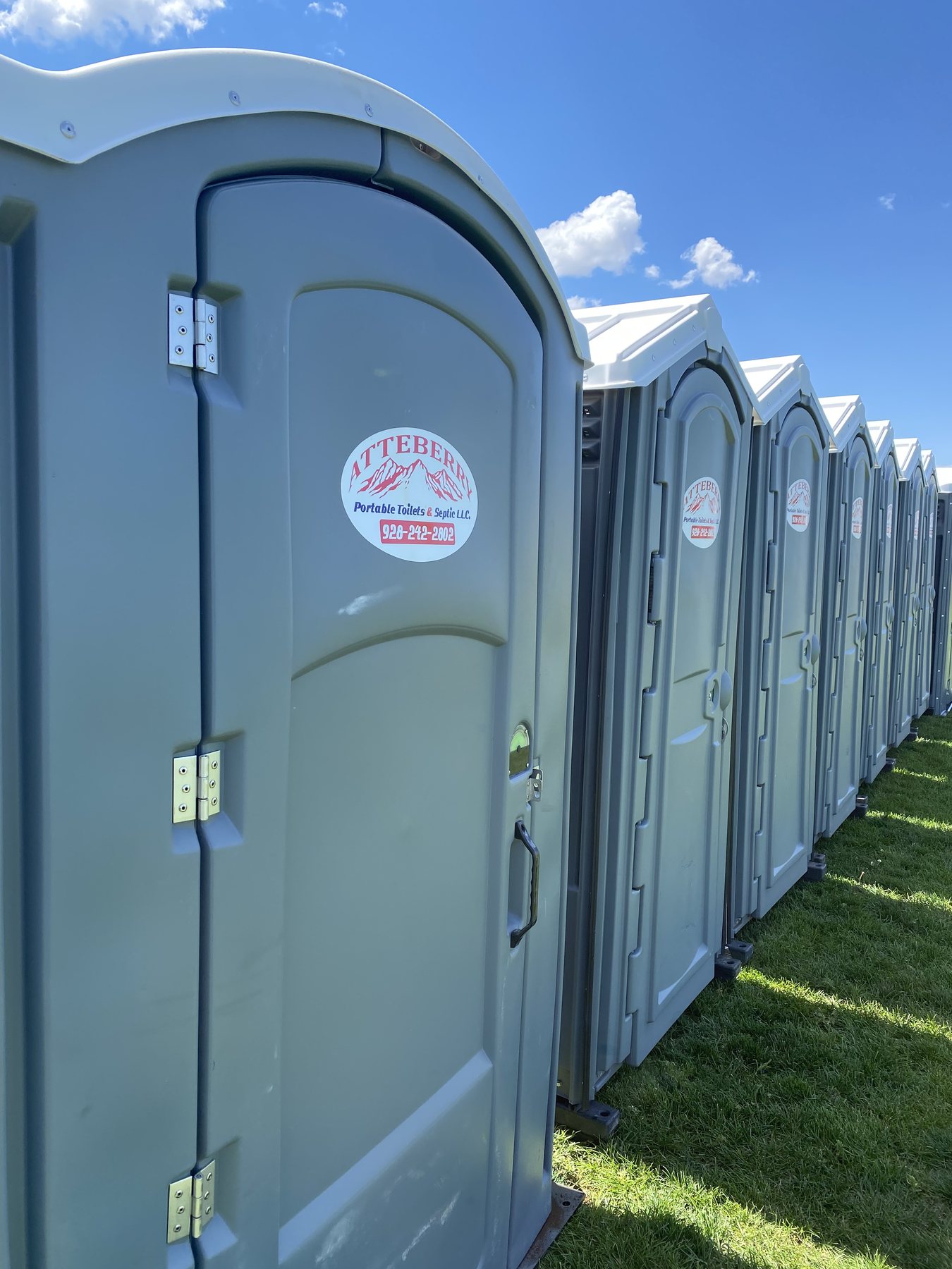 A long row of Atteberry portable toilets ready for construction site delivery